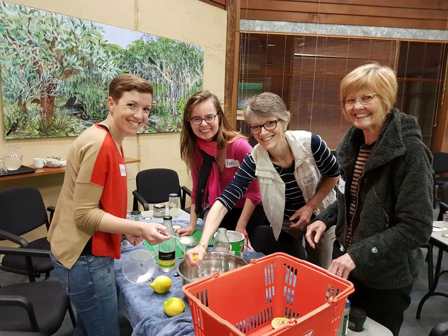 Four people at table with bowls creating natural cleaning supplies.